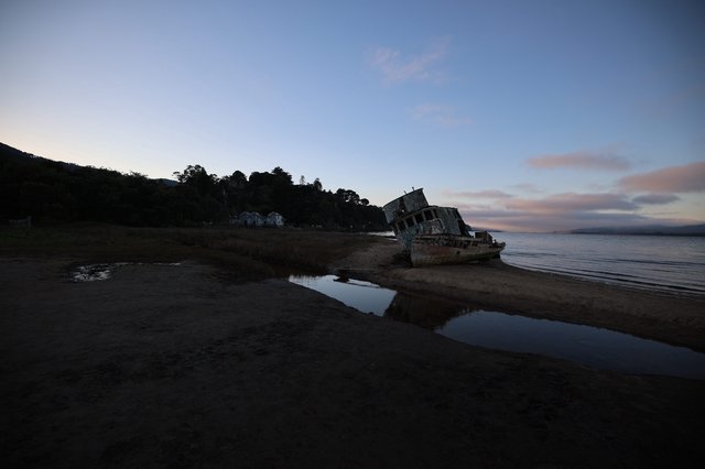 Abandoned Shipwreck at Dusk on Tidal Beach