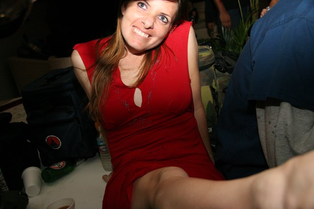 Smiling Woman in Red Dress at Indoor Party