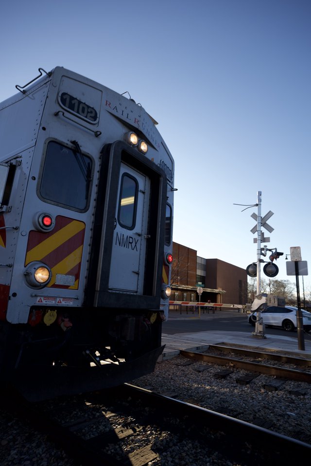 Commuter Train at Railroad Crossing During Twilight