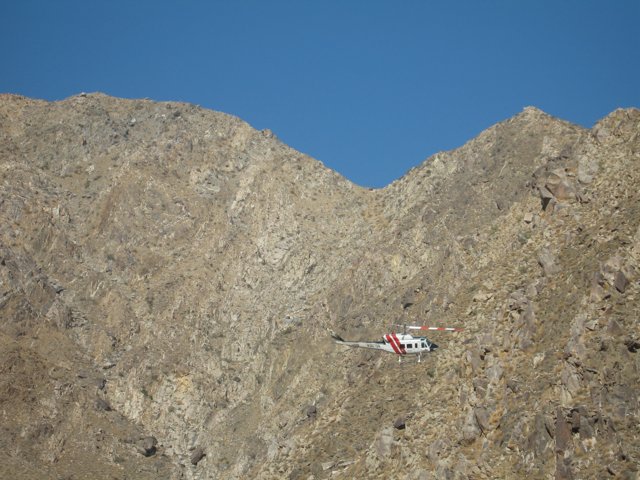Helicopter soaring over majestic mountain range