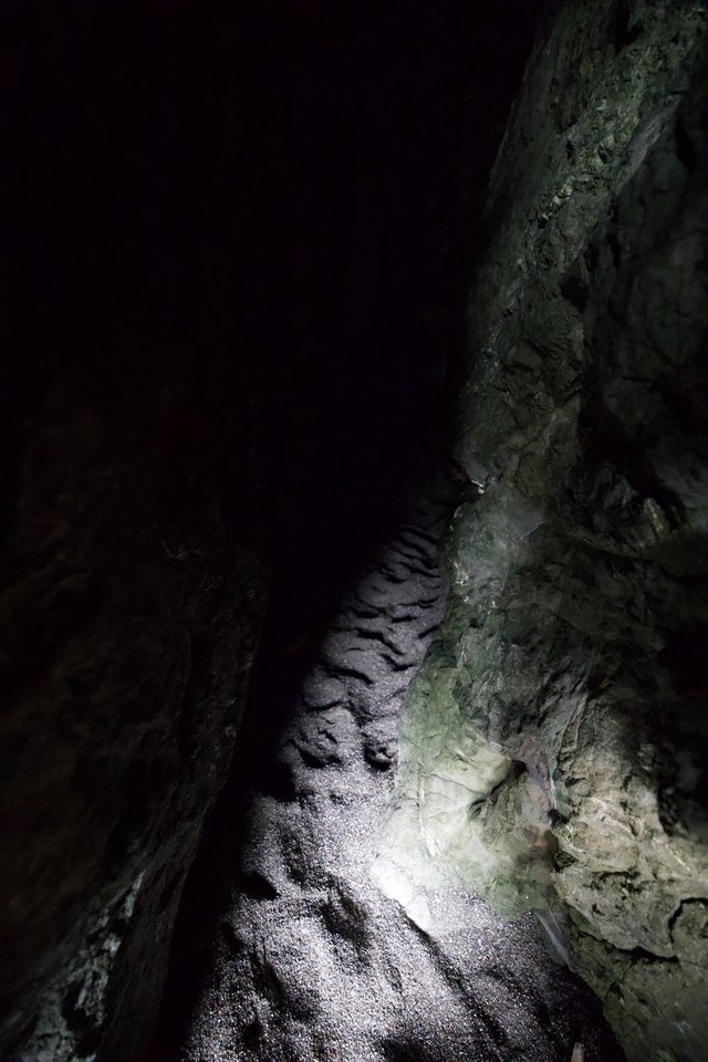 Narrow Cave Passage Illuminated by Single Light