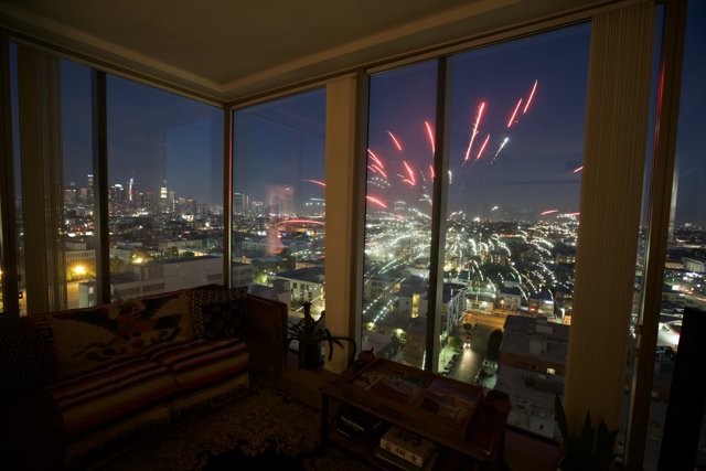 Fireworks Illuminate the City from a Living Room Window