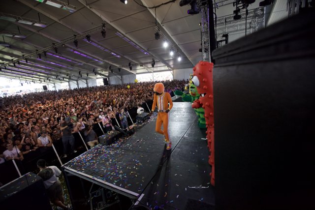 Orange-clad performer celebrates with crowd
