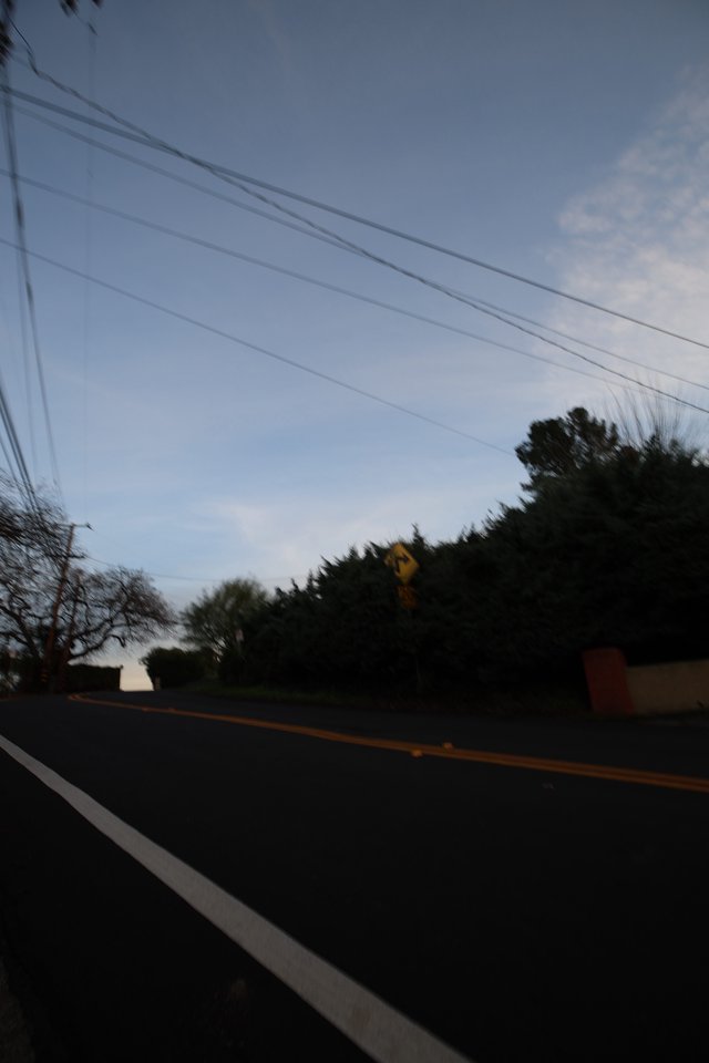 Dusk Road with Power Lines and Yellow Warning Sign