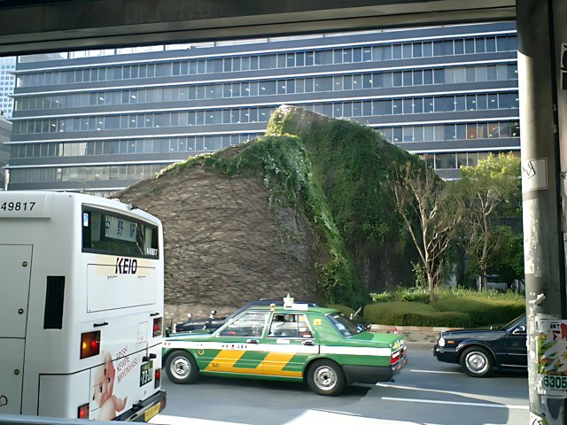 City Bus Passing by Greenery-Covered Building