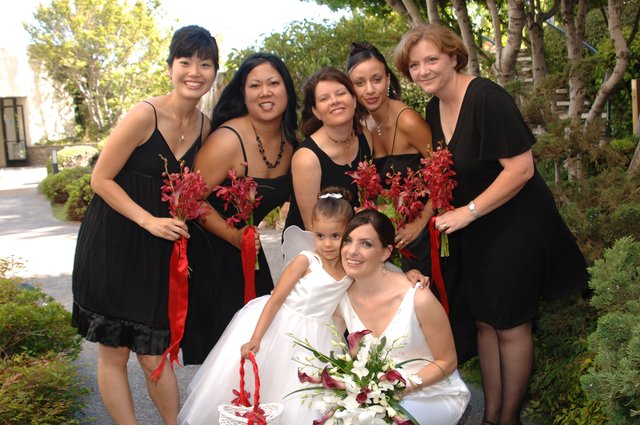 Bridal Party Poses in Black Dresses with Red Bouquets