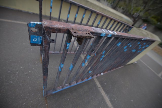 Rusted Metal Railing with Blue Accents on Urban Bridge