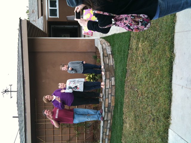 Family Waving Hello Outside Their Home