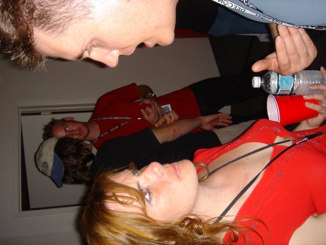 Woman in Red Looks Up at Man with Water Bottle