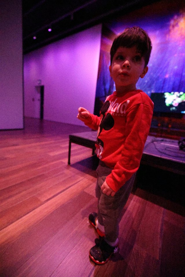 Young Boy Dancing at Purple-Lit Baby Rave Event