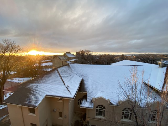 Snowy Roof Silhouetted by a Fiery Sunset