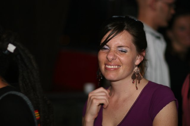 Joyful Woman Smiling at Nighttime Social Gathering