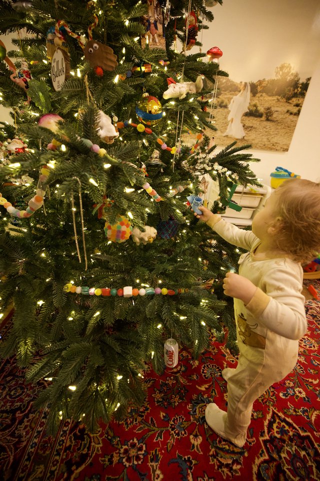Toddler Decorating Christmas Tree with Handmade Ornaments