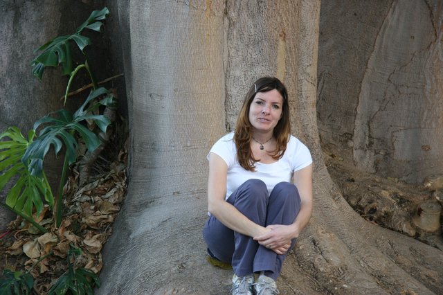 Woman Resting Against Massive Tropical Tree Roots