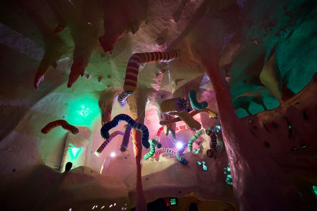 Whimsical Serpent Installation in Illuminated Cave Environment