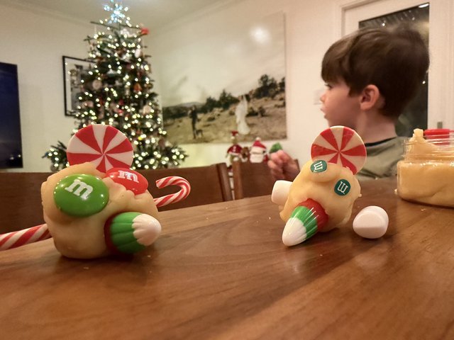 Child Decorating Christmas Candy Race Cars at Home