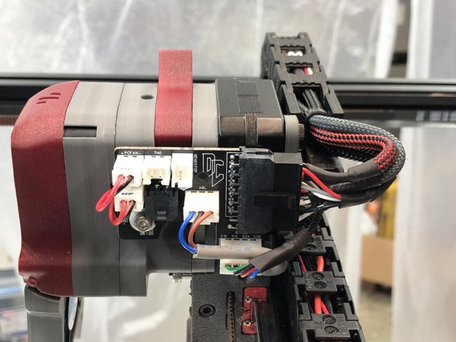 A Close Up of a Red and Black Machine with Wires Attached