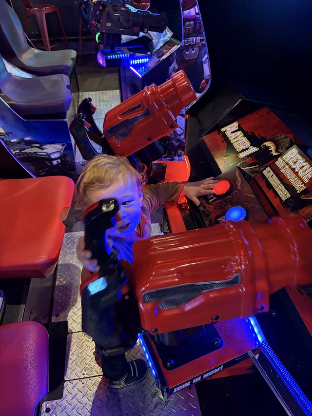 Young Child Playing Arcade Racing Game at Entertainment Venue