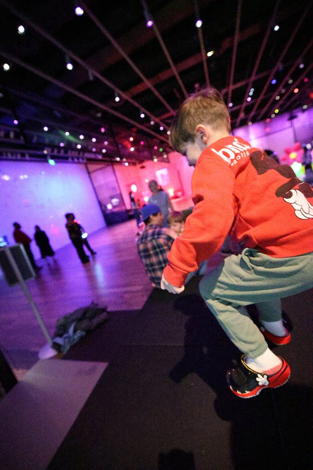 Child Dancing at Baby Rave Event Under Purple Lights