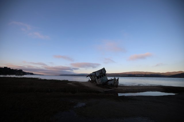 Abandoned Shipwreck at Twilight on Coastal Shore