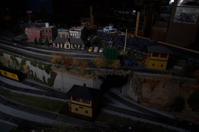 A Diorama of a Train Station with a Miniature Train Moving Along the Tracks