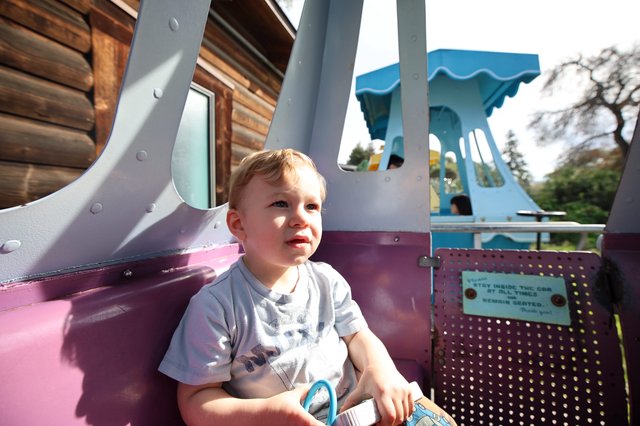 Young Child Enjoying Amusement Park Ride in Fantasyland