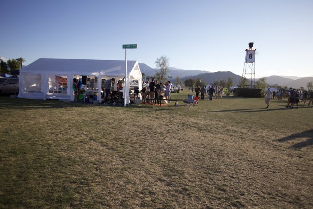 The Coachella 2012 Crowd Gathers in a Field with Blue Skies