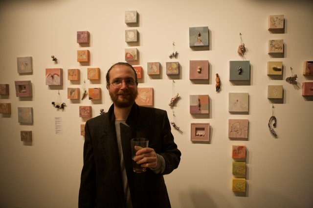 Man in Formal Wear Standing in Front of Wall of Art