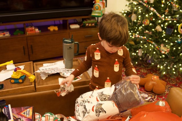 Child Opening Christmas Presents on Christmas Morning