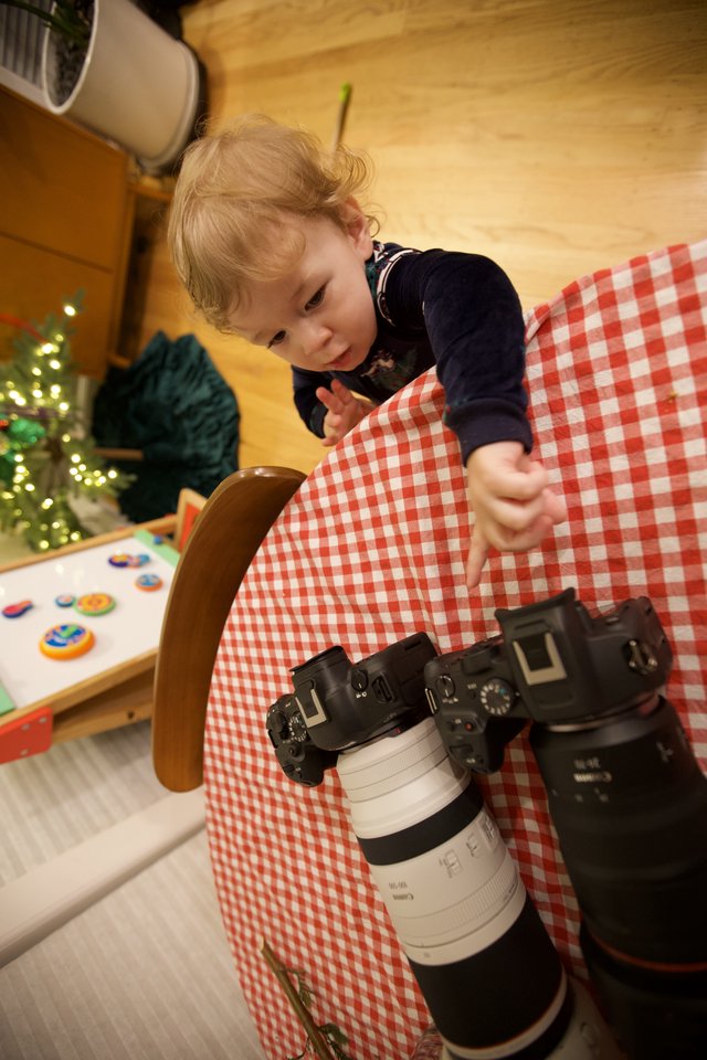 Young Child Exploring Professional Camera Equipment