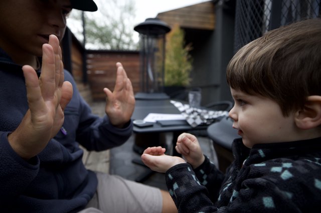 Father and Children Playing Hand Counting Game Outdoors