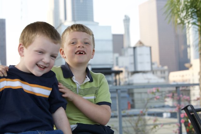 Two boys smiling in front of city skyline