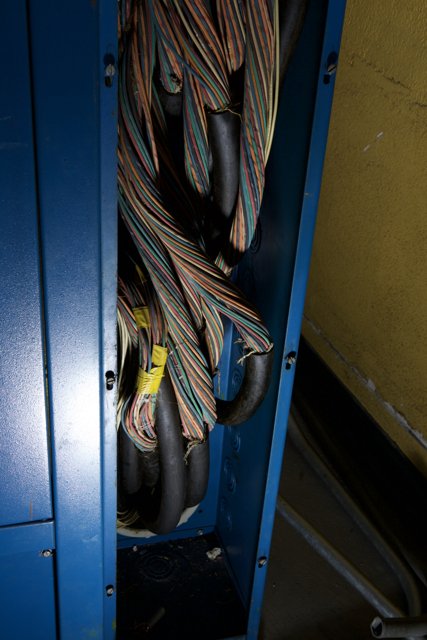 Tangled Wires in a Blue Cabinet
