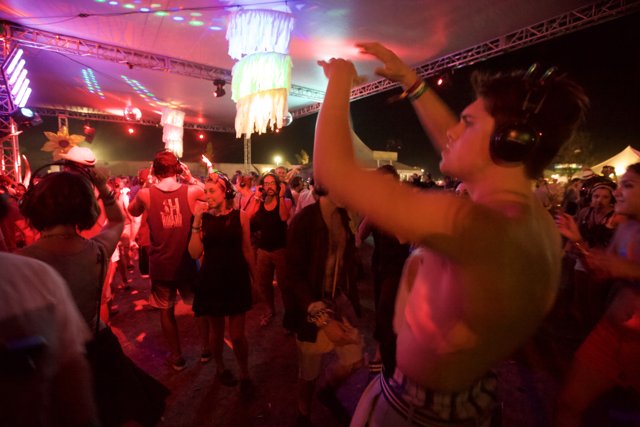 Shirtless Partygoer Dancing in Club Spotlight