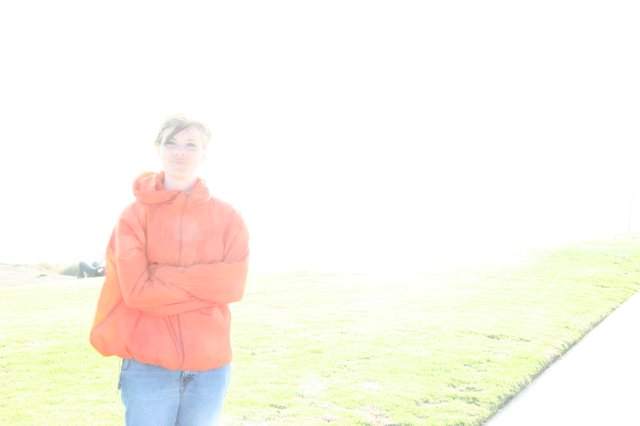 Overexposed Portrait of Woman in Orange Jacket Outdoors