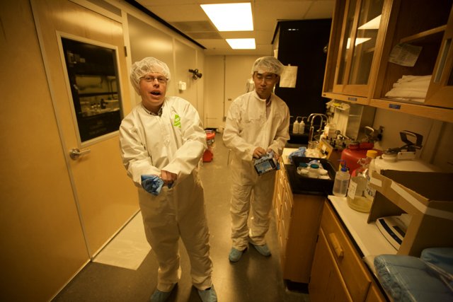 Two Scientists Working in a White Lab