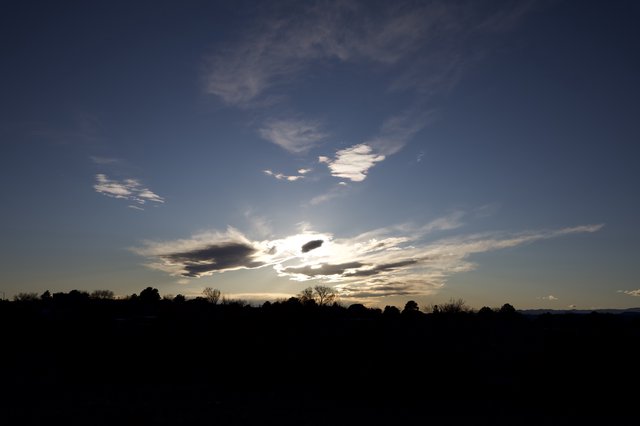 Dramatic Cloud Formation at Sunset Over Silhouetted Landscape