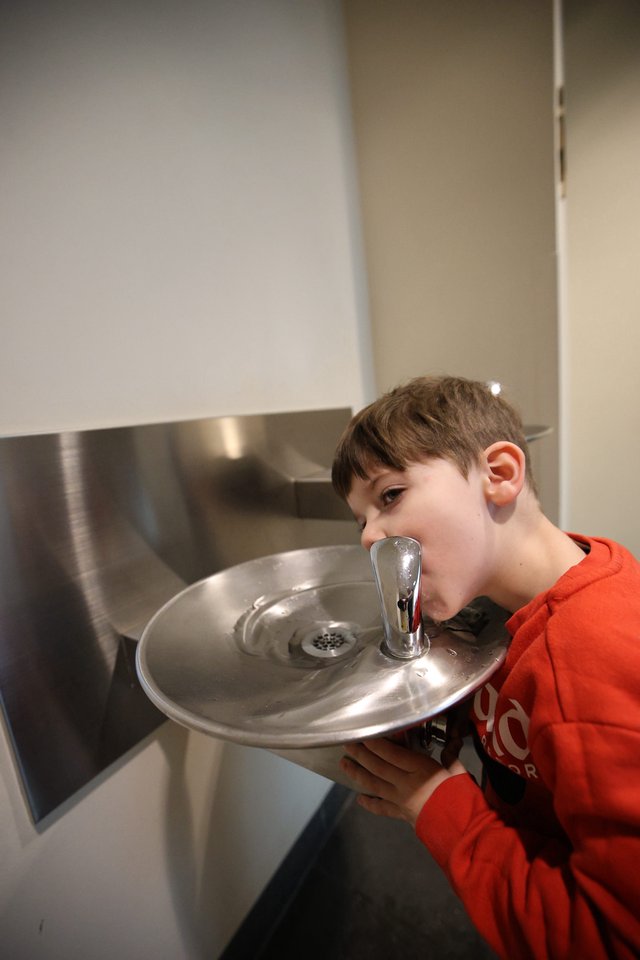 Young Boy Drinking from Water Fountain at Museum