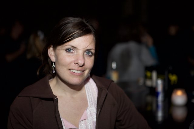 Smiling Woman at Dimly Lit Evening Venue