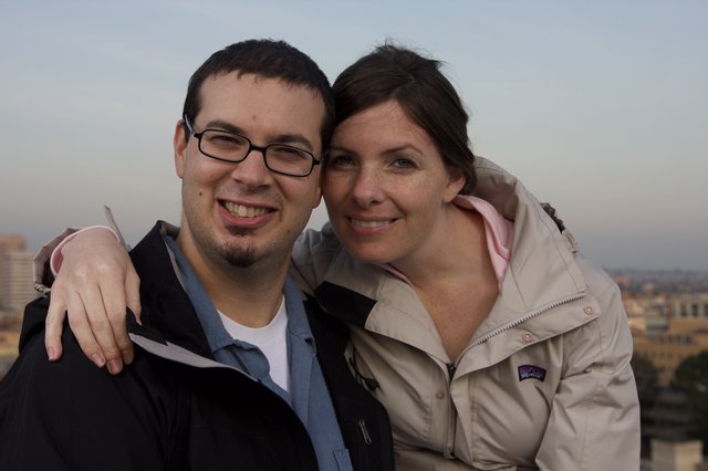 Smiling Couple Embracing Against City Skyline