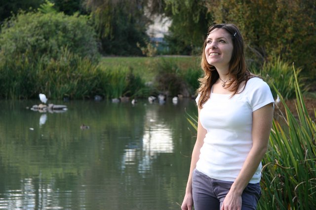 Smiling Woman by a Tranquil Park Pond