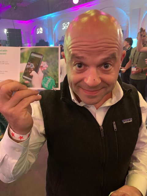 Bald man promoting person on card