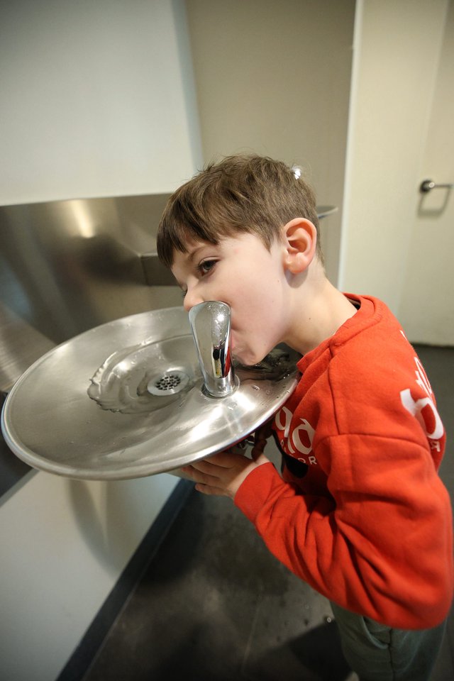 Young Boy Drinking from Water Fountain at Museum