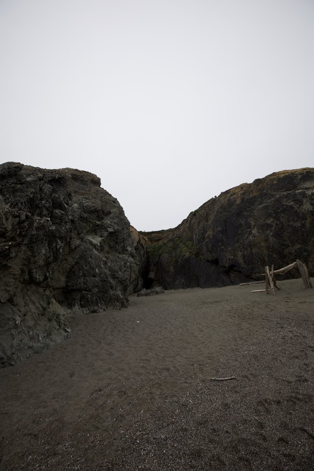 Dark Volcanic Cliffs Frame a Moody Coastal Cove