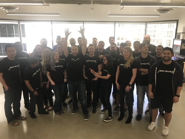 Group of People in Black Shirts Strike a Pose