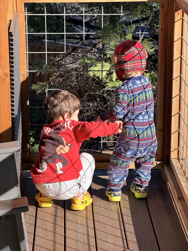 Two Young Children Exploring Deck in Holiday Outfits