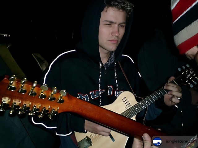 Ansel Elgort playing his acoustic guitar at Coachella