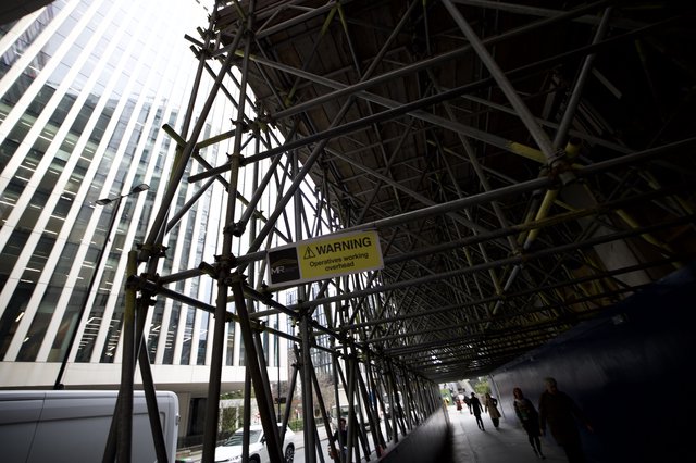 Urban Scaffolding Tunnel with Overhead Warning Sign