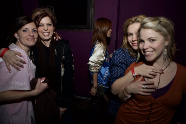 Friends Embrace at Dimly Lit Nightclub Party
