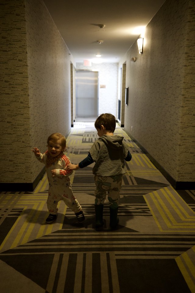 Two Young Children Playing in Hotel Corridor
